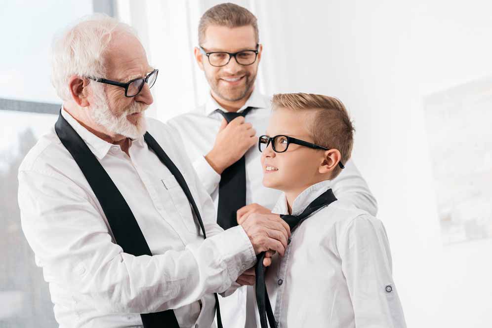 grand père qui aide son petit fils a faire un noeud de cravate